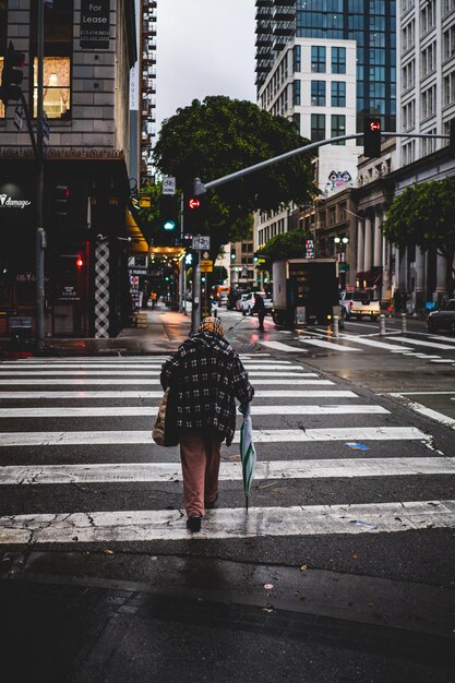 Foto vista traseira em todo o comprimento de um homem caminhando na estrada