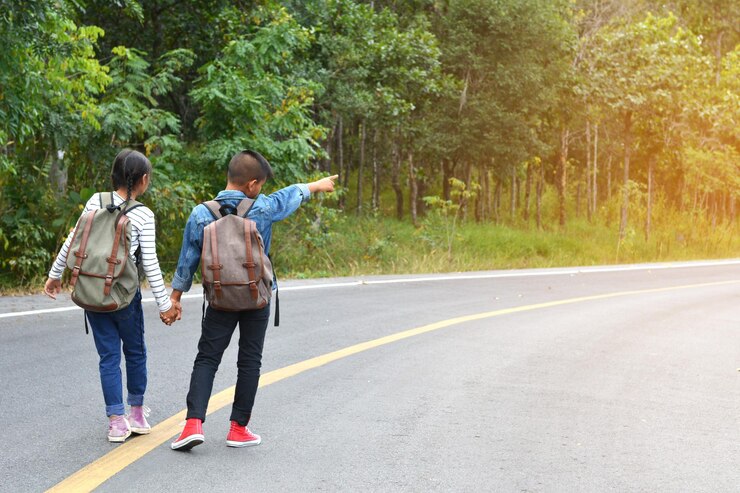 Foto vista traseira em todo o comprimento do menino com a irmã apontando para a estrada