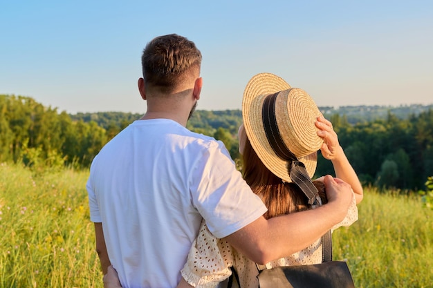 Vista traseira feliz casal de meia-idade olhando para o horizonte na natureza de verão