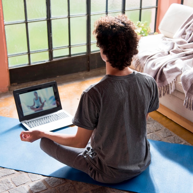 Foto vista traseira homem meditando em casa