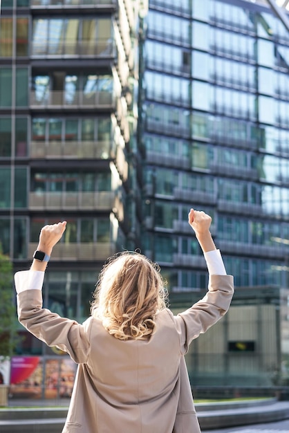 Foto vista trasera de una abogada corporativa que celebra levantar las manos y triunfar para lograr el objetivo o el éxito