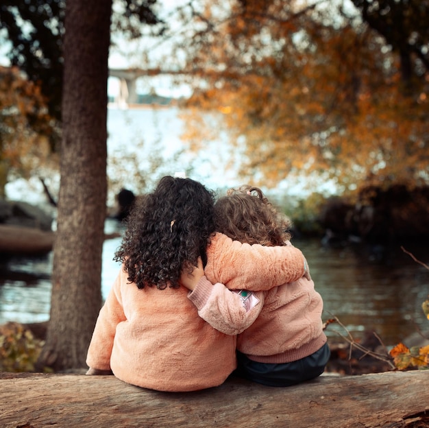 Foto vista trasera de amigos sentados en un tronco en otoño