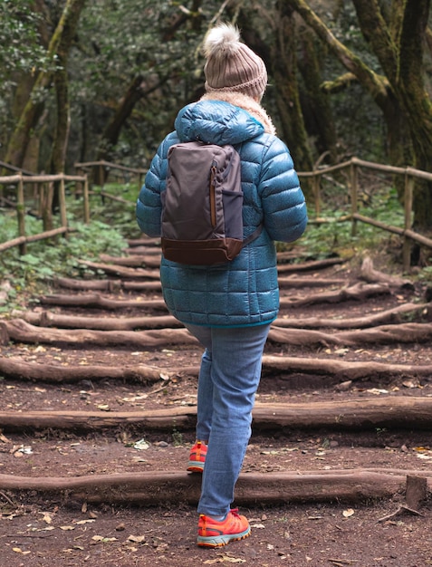 Vista trasera de una anciana con una mochila caminando en el parque nacional de Garajonay en La Gomera