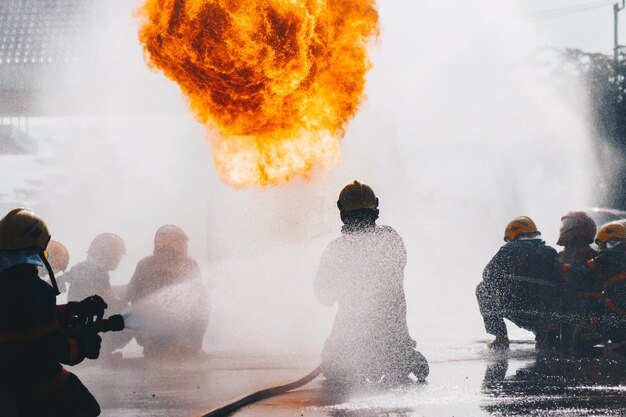 Foto vista trasera de los bomberos apagando el fuego