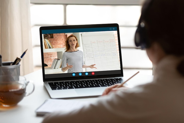 Foto vista trasera de cerca mujer con auriculares viendo un webinar