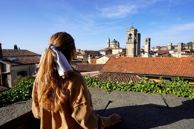 Vista trasera de una chica mirando el paisaje urbano de Bérgamo Lombardía Italia