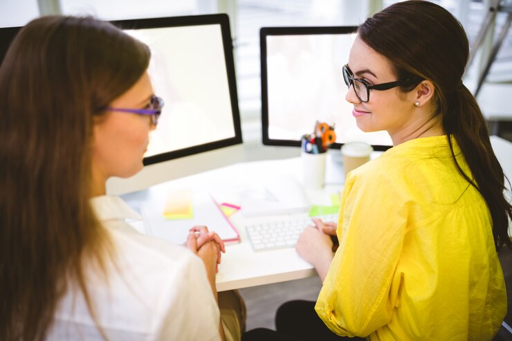 Foto vista trasera de compañeros de trabajo sentado en la oficina creativa