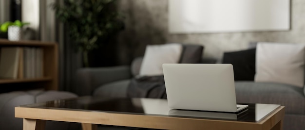 Una vista trasera de una computadora portátil en una mesa de café en una sala de estar de loft contemporánea