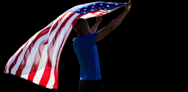 Vista trasera del deportista levantando una bandera americana