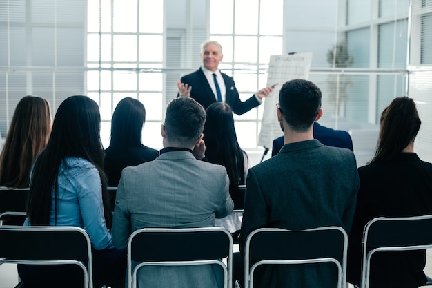 Vista trasera. empleados de la empresa aplaudiendo en una reunión de trabajo. concepto de éxito