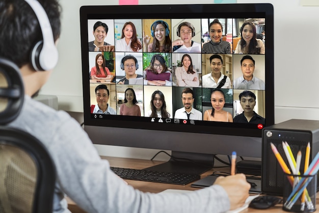 Vista trasera del empresario asiático trabajando y reunión en línea a través de videoconferencia con colega