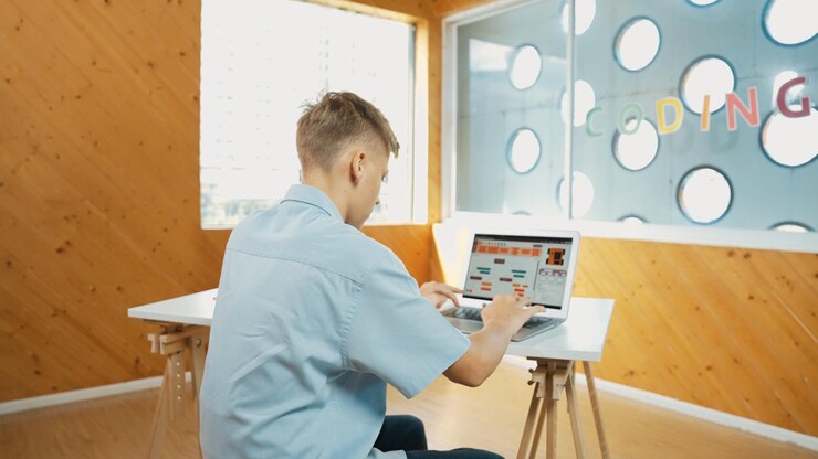 Foto vista trasera de un estudiante de secundaria trabajando en el análisis de datos de la computadora portátil edificación
