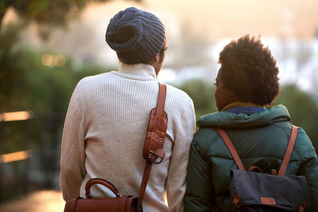 Foto vista trasera estudiante universitario y amigos al aire libre en el campus contemplar y relajarse con mochila en clima frío universidad interracial y compañero de clase para relajarse pensar y planear para la asignación