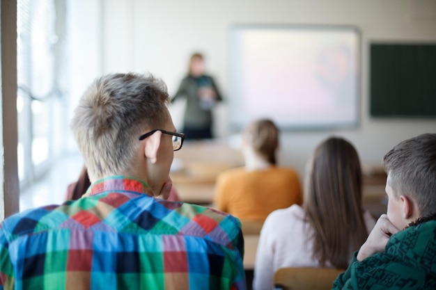 Foto vista trasera de los estudiantes sentados en el aula