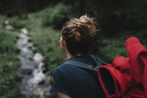 Vista trasera de un excursionista que lleva una mochila en el bosque