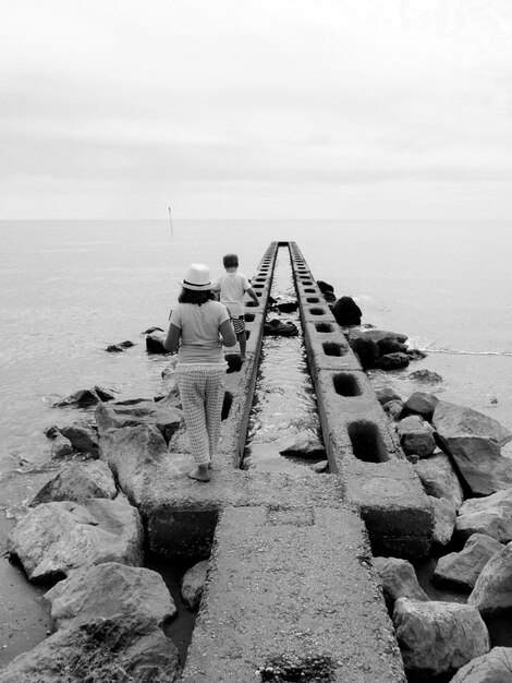 Foto vista trasera de los hermanos en una estructura construida en el mar