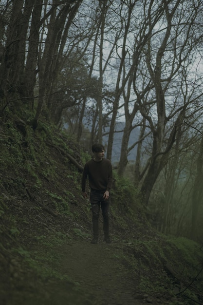 Foto vista trasera de un hombre caminando por el bosque