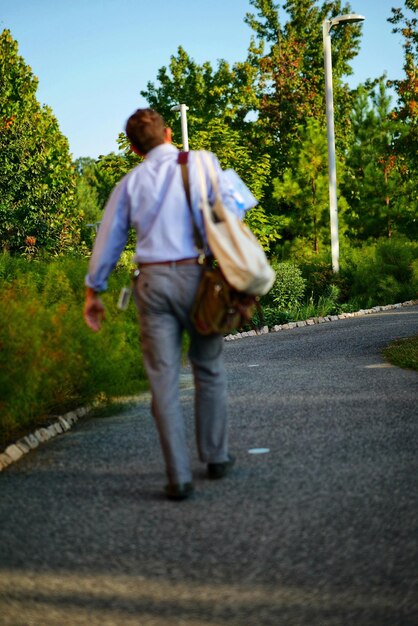 Foto vista trasera de un hombre caminando por la carretera