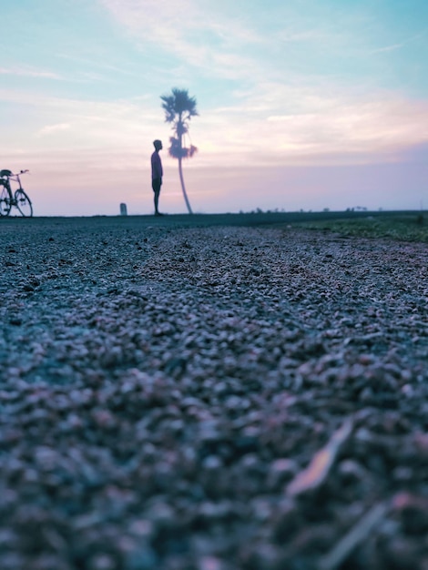 Foto vista trasera de un hombre caminando por la mañana contra el cielo durante el amanecer