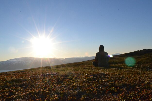 Foto vista trasera de un hombre en el campo contra el cielo durante la puesta de sol