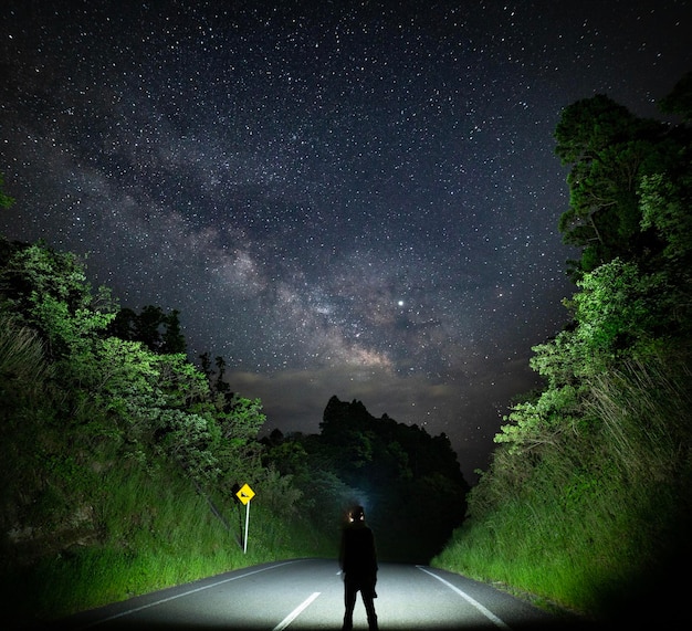 Foto vista trasera de un hombre en la carretera contra el cielo nocturno