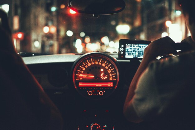 Foto vista trasera de un hombre conduciendo un coche por la noche