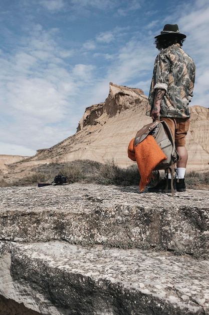 Vista trasera del hombre en una excursión para descubrir tierras salvajes en vacaciones hombre con pasión por los viajes de pie en un paisaje rocoso