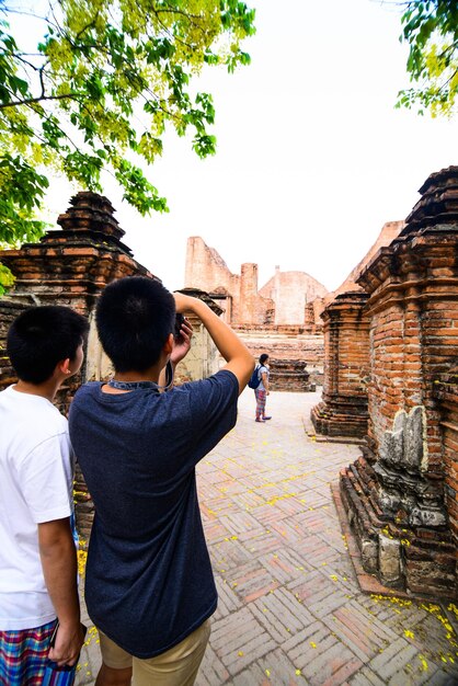 Foto vista trasera de un hombre fotografiando en el templo