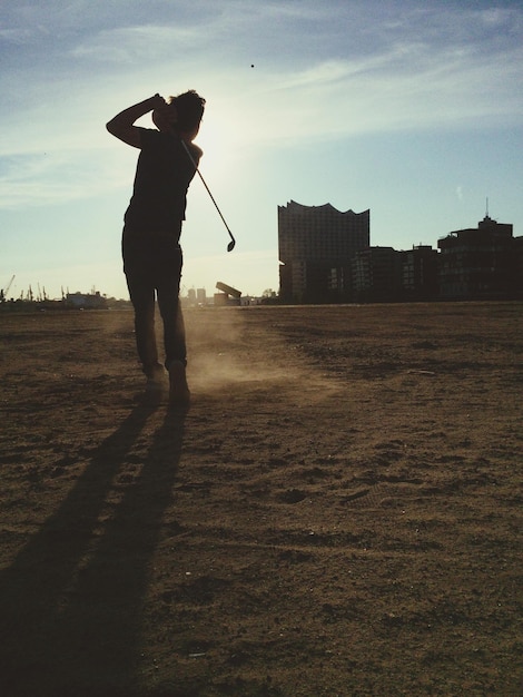Foto vista trasera de un hombre jugando al golf al anochecer