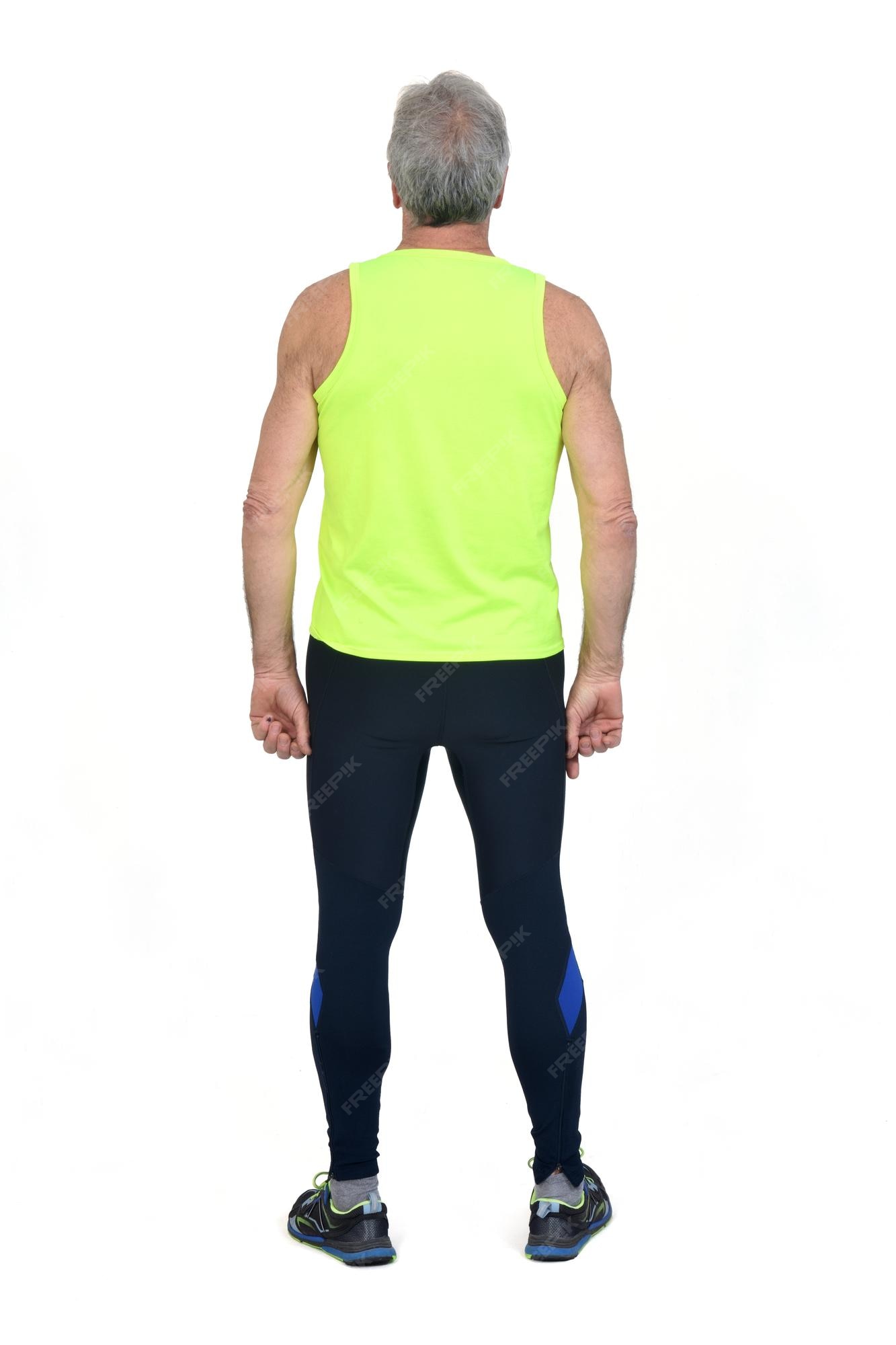 Vista trasera de un hombre con medias de ropa deportiva y amarillo  fluorescente sobre fondo blanco. | Foto Premium