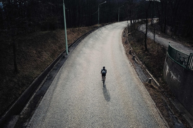 Vista trasera de un hombre montando una bicicleta en la carretera