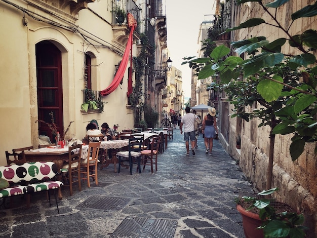 Foto vista trasera de un hombre y una mujer caminando por una cafetería en la calle en medio de los edificios