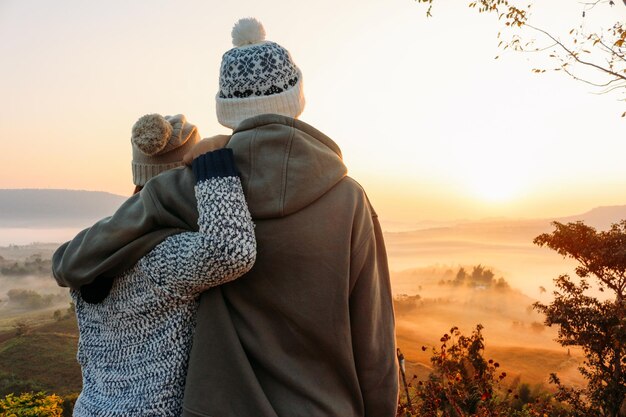 Foto vista trasera de un hombre y una mujer contra el cielo durante la puesta de sol