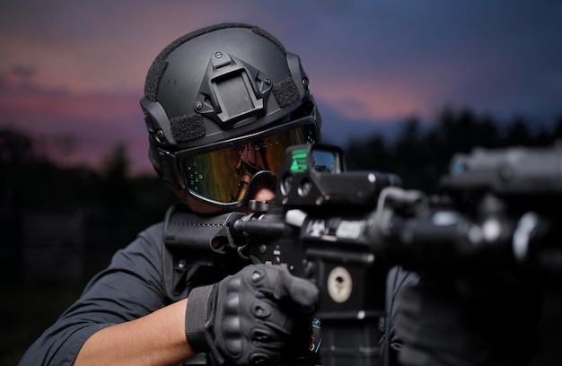 Vista trasera de un hombre de pie contra el cielo con armas y equipos por la noche