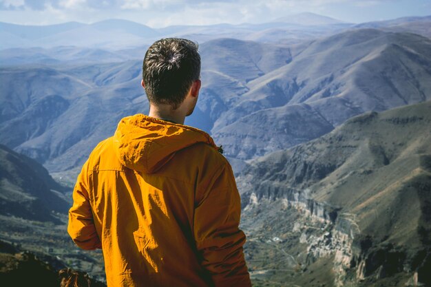 Foto vista trasera de un hombre de pie contra las montañas