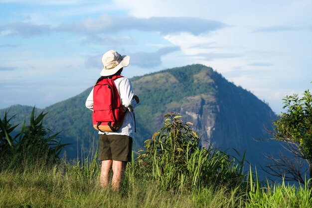 Vista trasera de un hombre de pie en la montaña contra el cielo