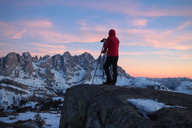 Vista trasera de un hombre de pie en una montaña salvaje contra el cielo - Alpes dolomitas pálido di san martino