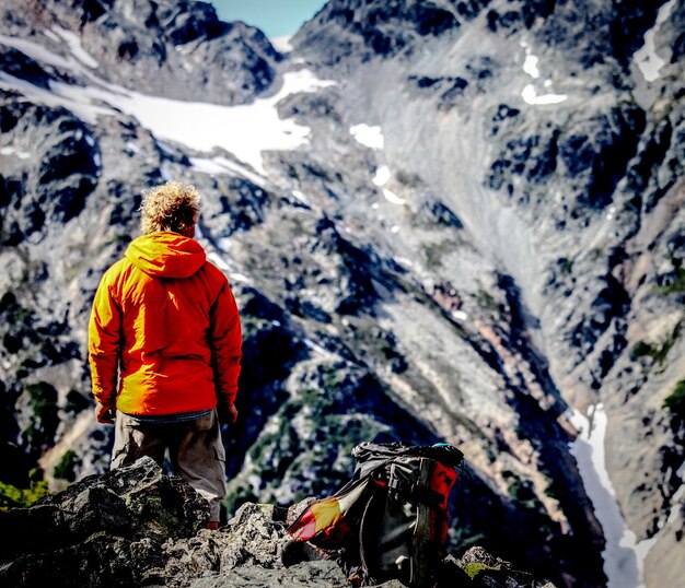 Foto vista trasera de un hombre de pie en la montaña