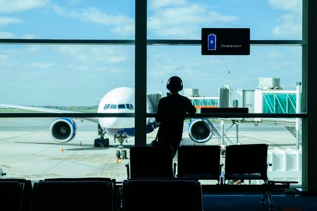 Vista trasera de un hombre de pie en la sala de espera en el aeropuerto