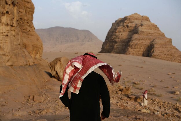 Foto vista trasera de un hombre con ropa tradicional en el desierto