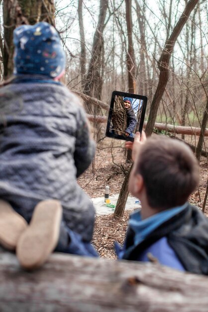 Foto vista trasera de un hombre sentado en la madera en el bosque