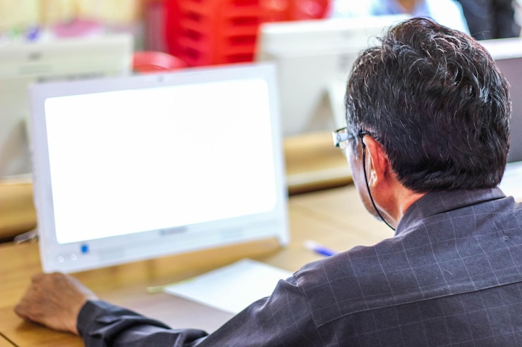 Foto vista trasera de un hombre usando una computadora en la oficina