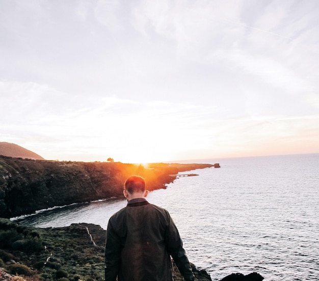 Vista trasera de un hombre con vistas al mar tranquilo