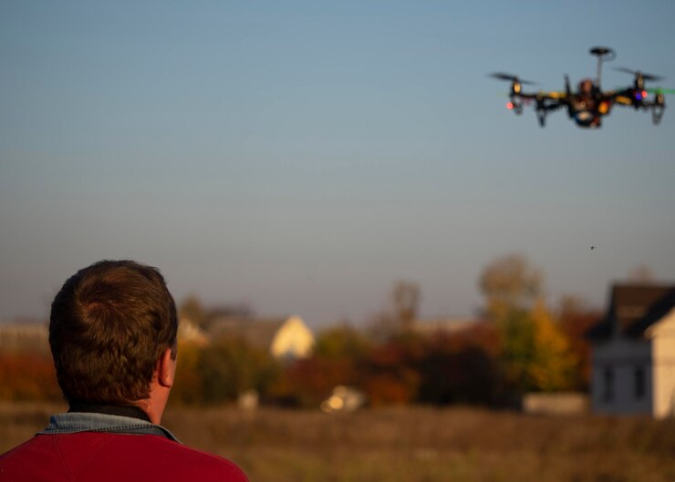 Foto vista trasera de un hombre volando un dron contra el cielo