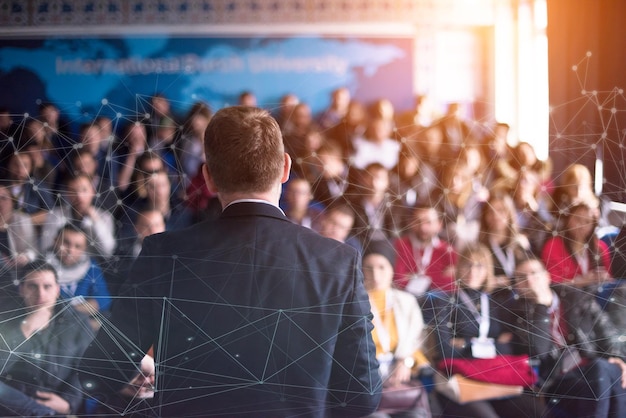 Foto vista trasera de un joven hombre de negocios exitoso en la sala de conferencias de negocios con presentaciones públicas. público en la sala de conferencias. club de emprendedores