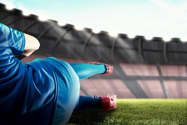 Vista trasera de un jugador de fútbol con una camiseta azul abordando la pelota