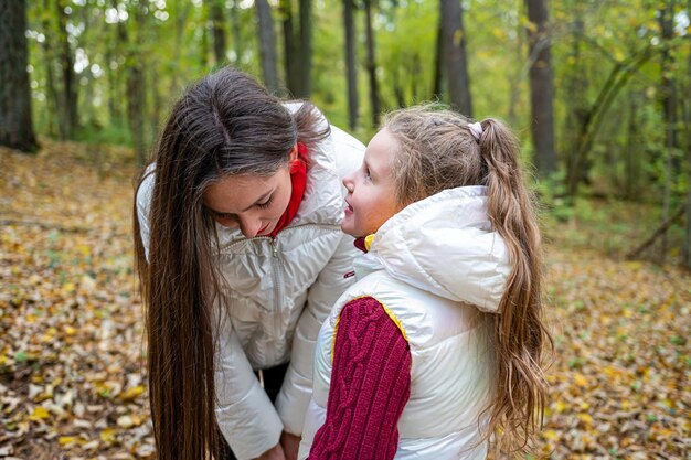 Foto vista trasera de madre e hija en el bosque