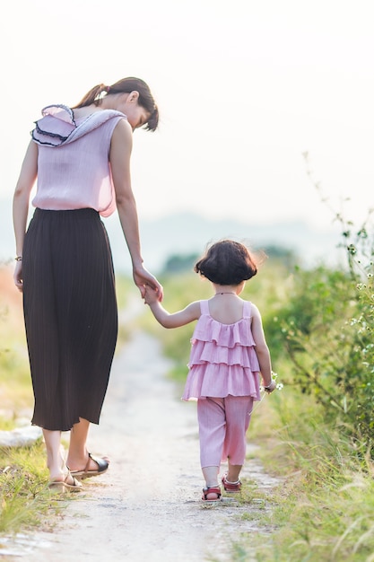 Vista trasera de madre paseando con su hija