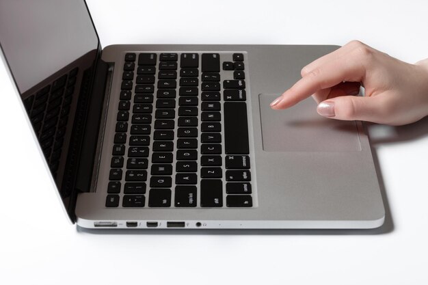 Vista trasera de las manos de una mujer de negocios ocupadas usando una computadora portátil en el escritorio de la oficina con copyspace