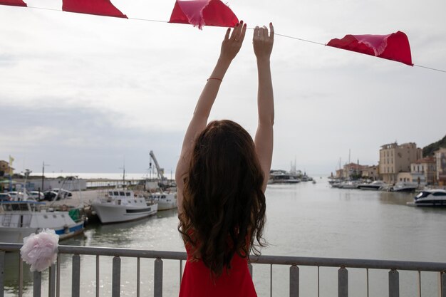 Foto vista trasera de una mujer con una bandera colgada en el puerto